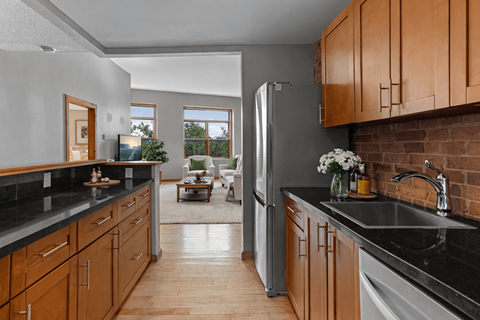 A kitchen with wooden cabinets and a black countertop.