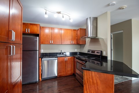 A kitchen with wooden cabinets and a black countertop.
