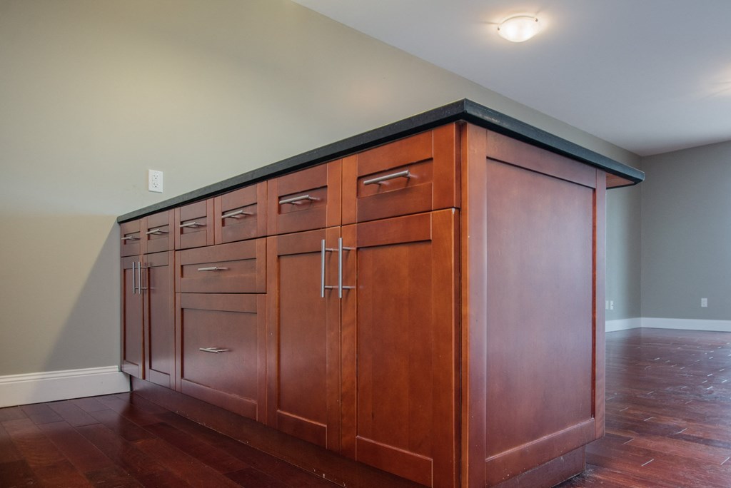 a kitchen with wood cabinets and a wood floor