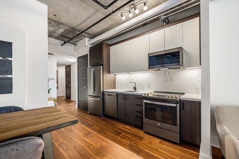 a kitchen with white cabinets and stainless steel appliances and a wooden floor