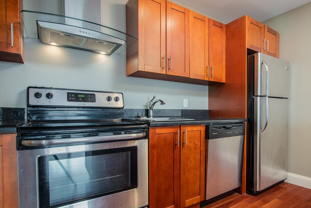 a kitchen with stainless steel appliances and wooden cabinets