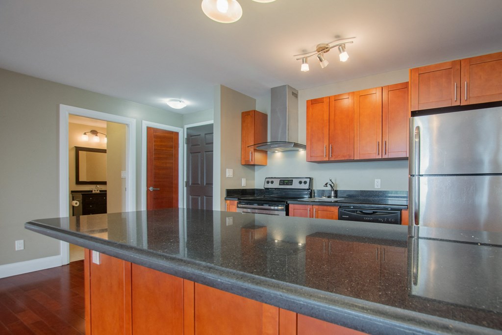 a kitchen with a large counter top and a stainless steel refrigerator
