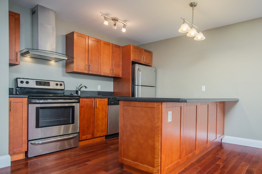 a kitchen with wooden cabinets and stainless steel appliances