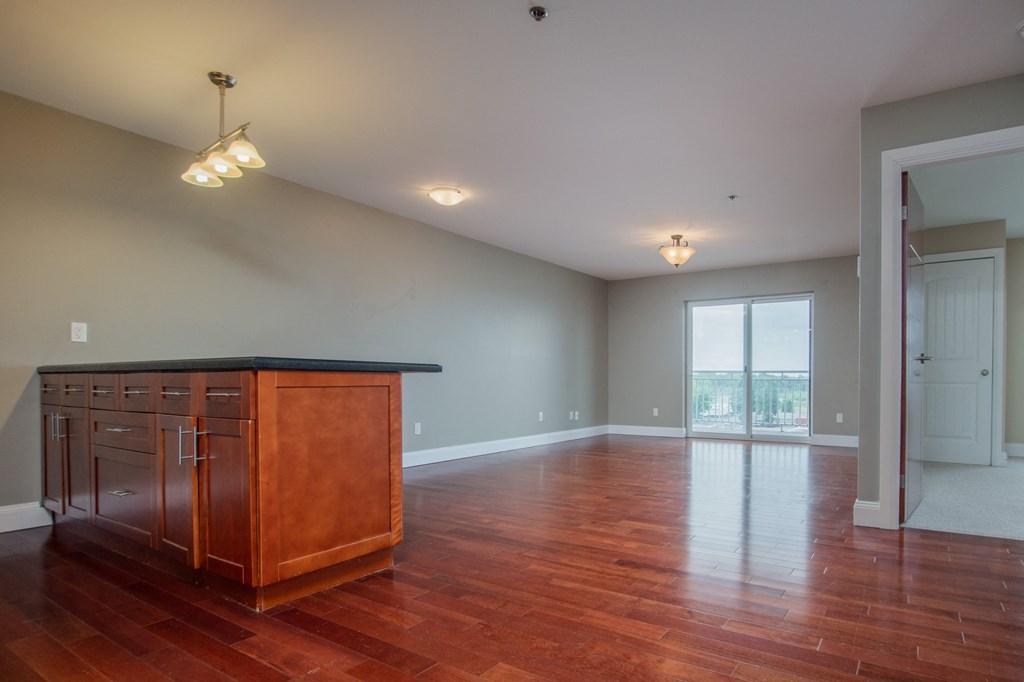 an empty living room with a wooden island in the middle