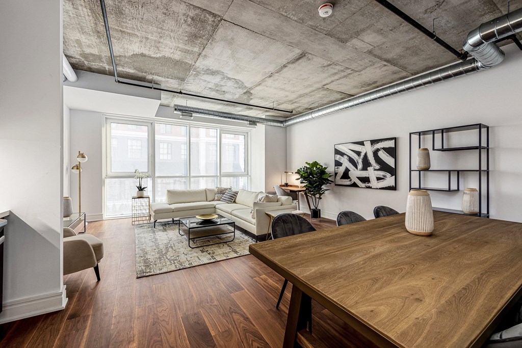 a living room with a wooden dining table and white couches