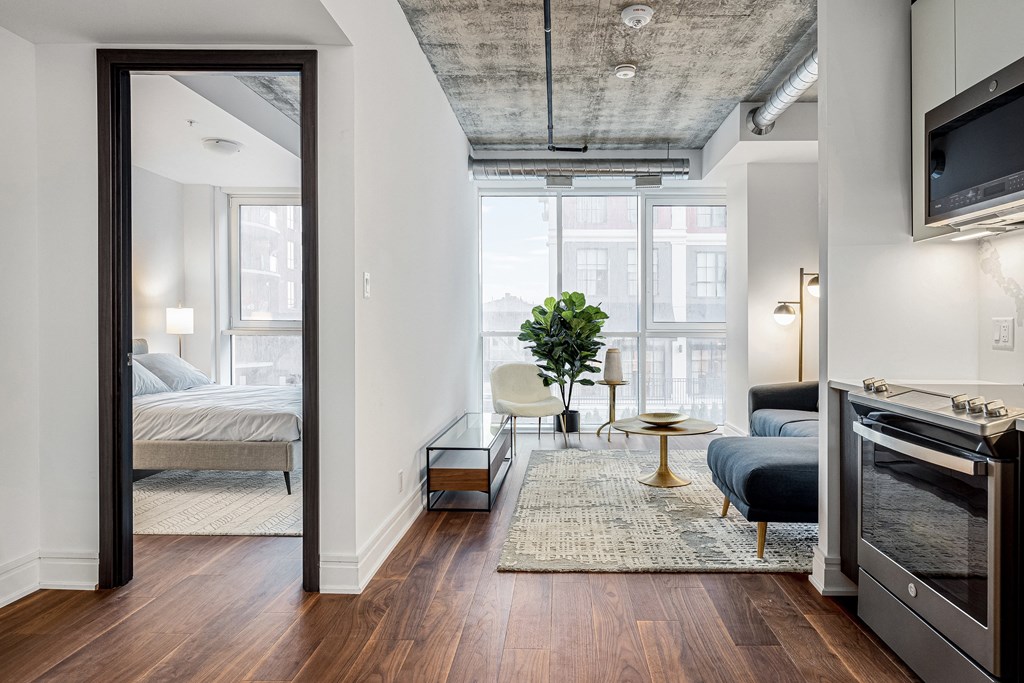 a bedroom with a bed and a tv in a room with hardwood floors