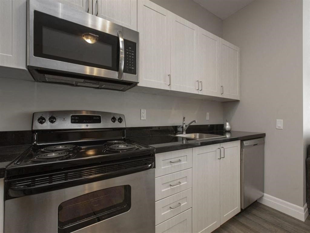 a kitchen with stainless steel appliances and white cabinets