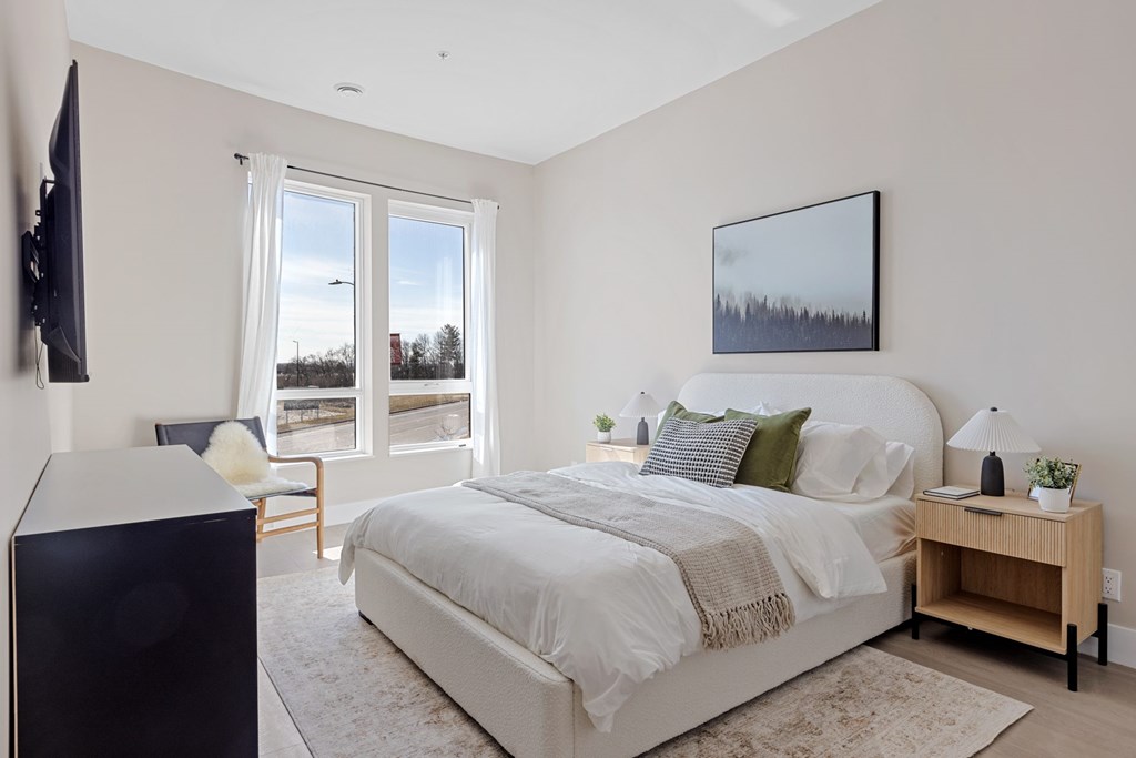 A bedroom with a large bed and a flat screen TV mounted on the wall at The Woods at 180 Kanata Avenue, Kanata, K2K 3L9