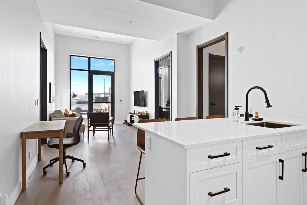 A modern kitchen with white cabinets and a large window at The Woods at 180 Kanata Avenue, Kanata, K2K 3L9