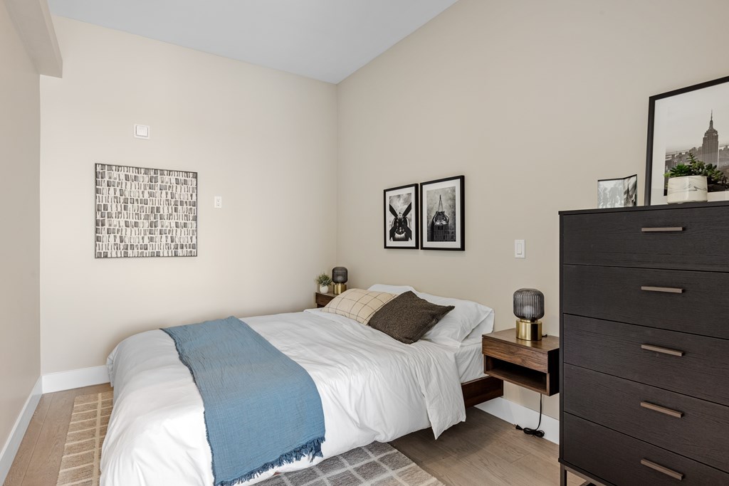 A bedroom with a white bed and a blue blanket at The Woods at 180 Kanata Avenue, Kanata, Ontario