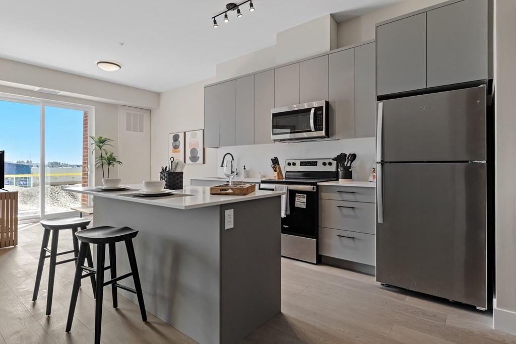 A modern kitchen with a refrigerator, microwave, and stove at The Woods at 180 Kanata Avenue, Ontario, K2K 3L9