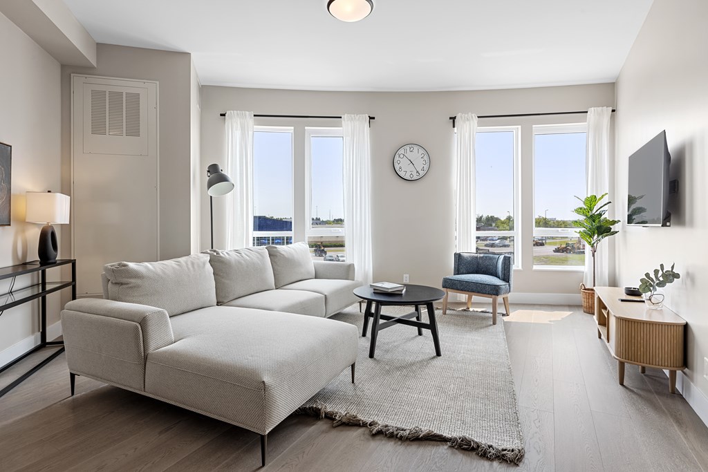 A living room with a grey sofa and a wooden coffee table.