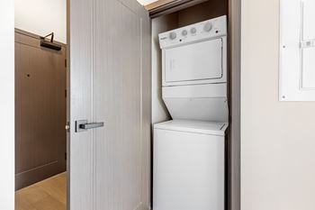 A white dishwasher and oven are built into a cabinet in a kitchen at The Woods at 180 Kanata Avenue, Kanata