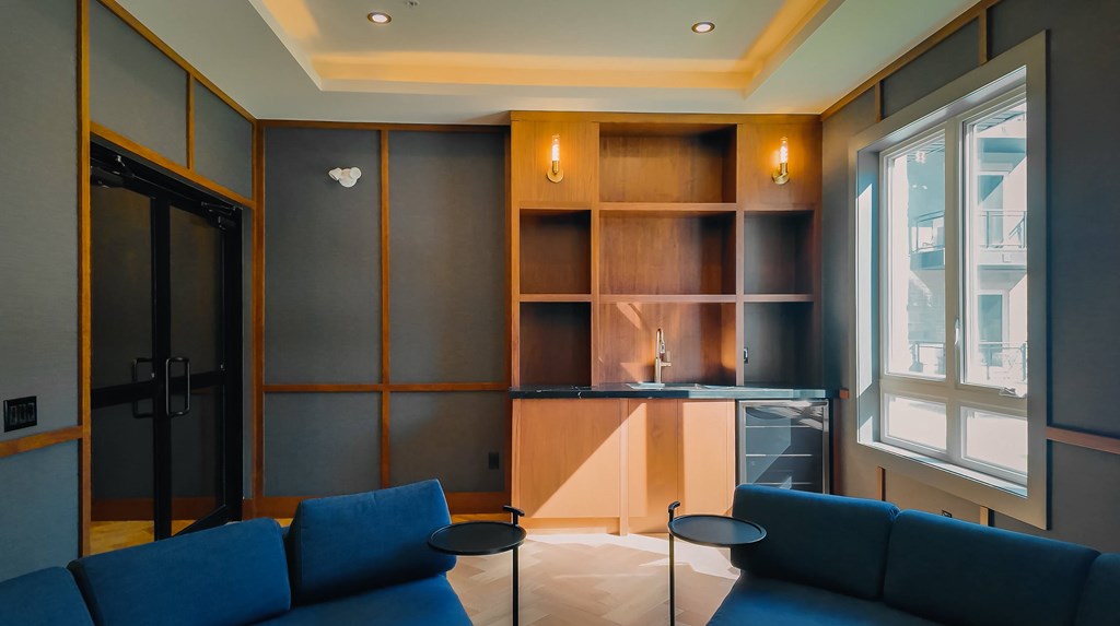 A living room with a blue couch and a wooden shelf.