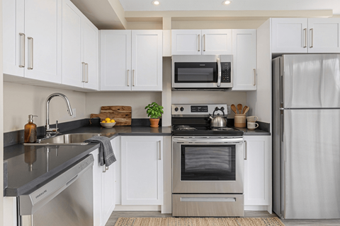 A modern kitchen with white cabinets and stainless steel appliances.