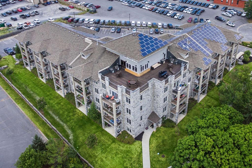 an aerial view of an apartment building with a parking lot