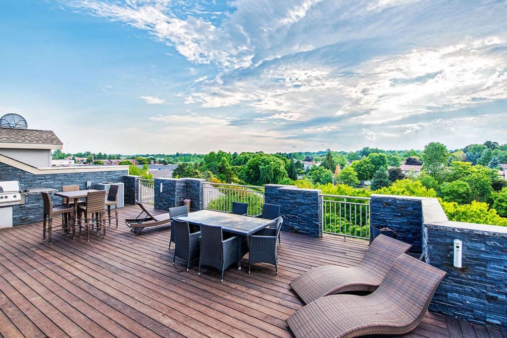 a patio with a table and chairs on top of a roof