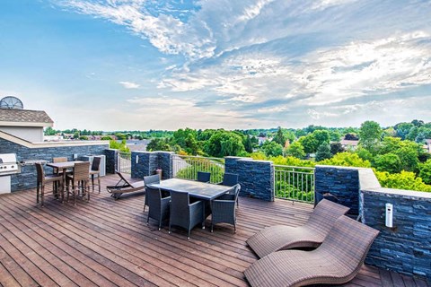 a patio with a table and chairs on top of a roof