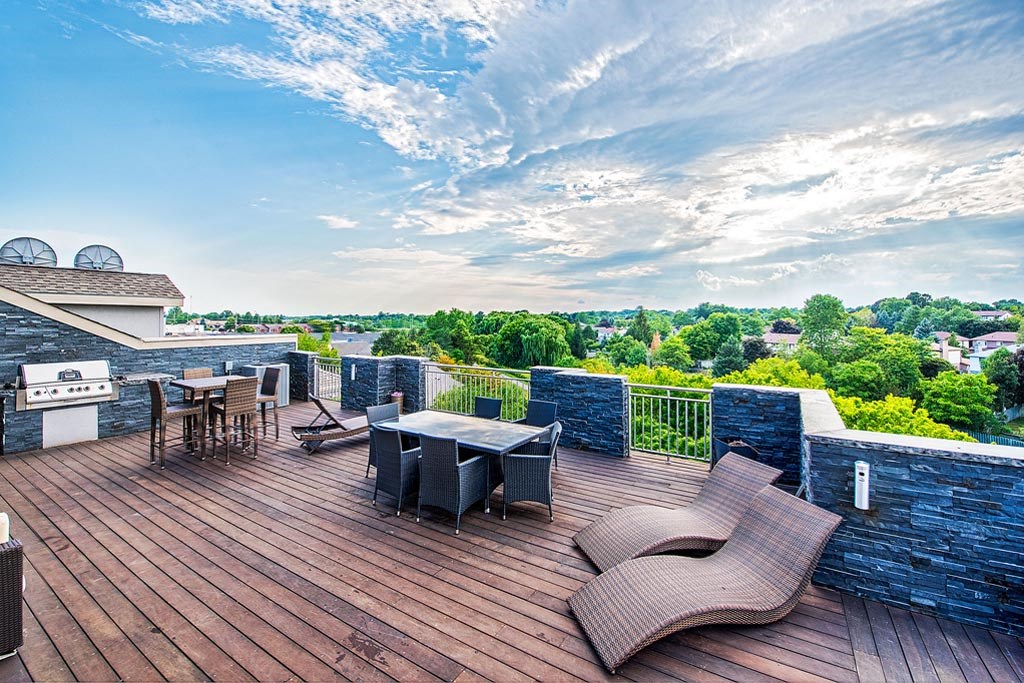 a deck with a table and chairs on top of a roof