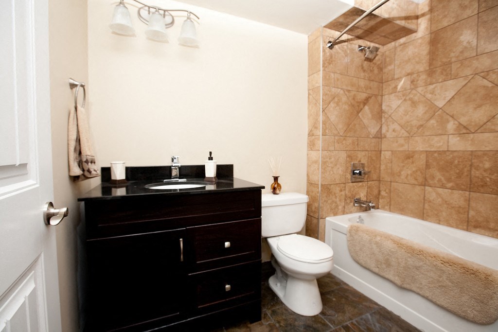 a bathroom with a toilet and a sink and a bath tub