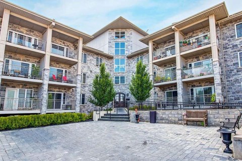 an exterior view of an apartment building with a courtyard and benches
