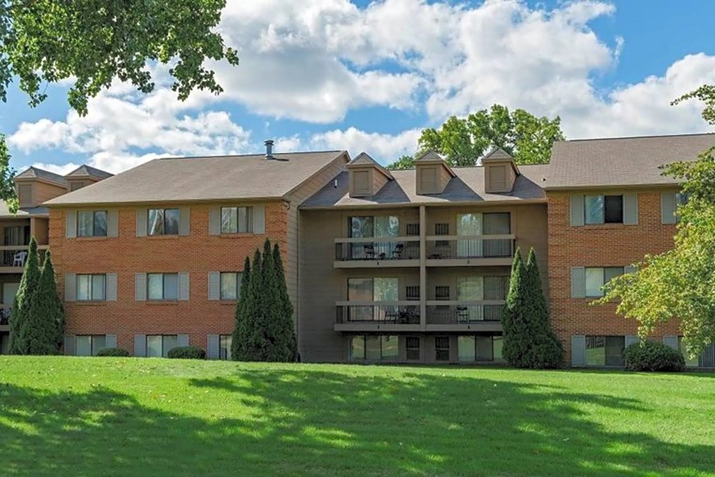 an apartment building with a green lawn in front of it