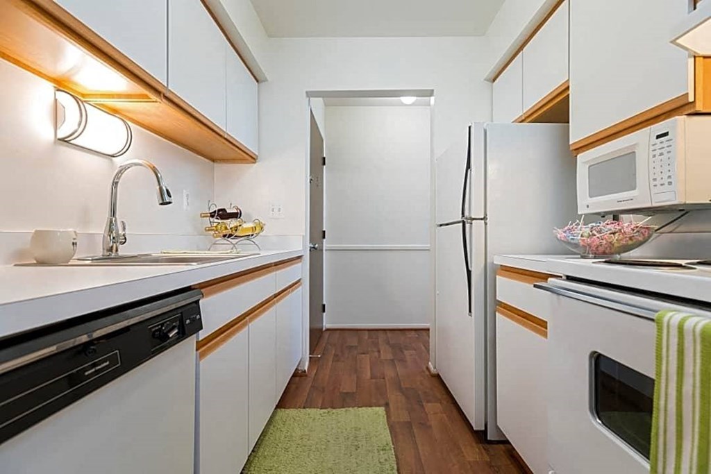 a kitchen with white cabinets and a white refrigerator