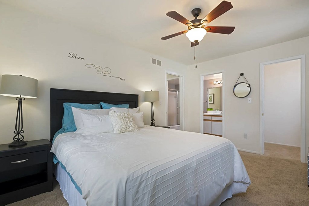 a bedroom with a bed and a ceiling fan