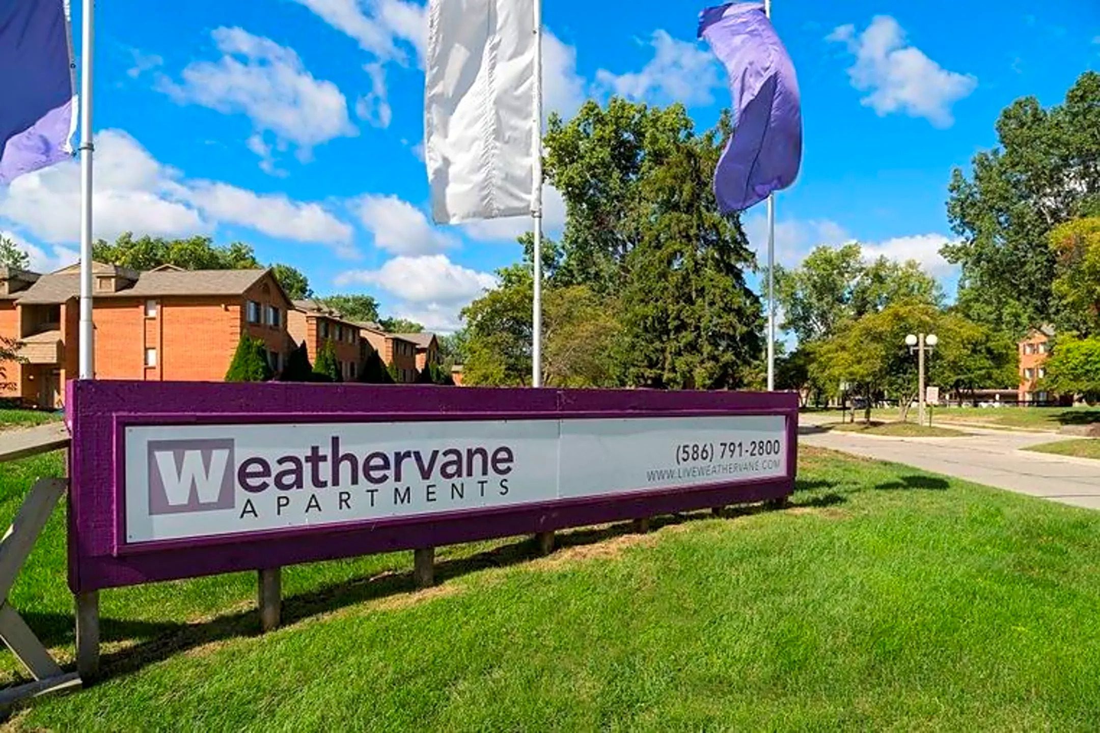 a sign apartments in front of a street with flags