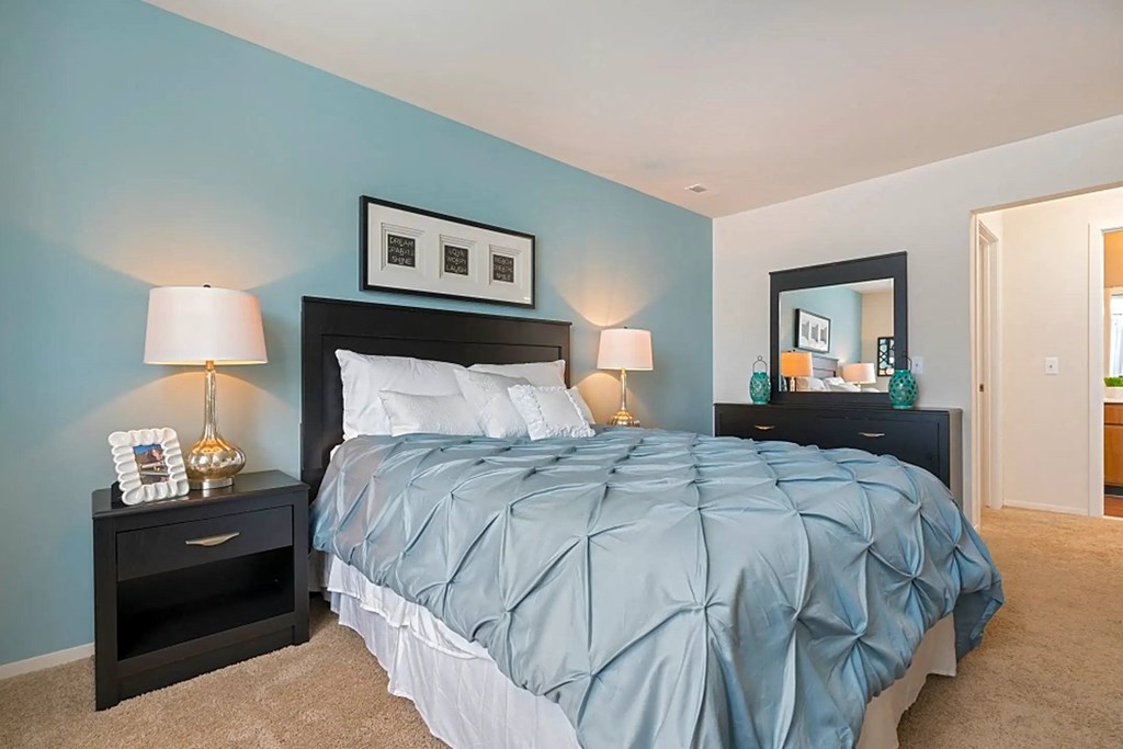 a bedroom with a blue wall and a bed