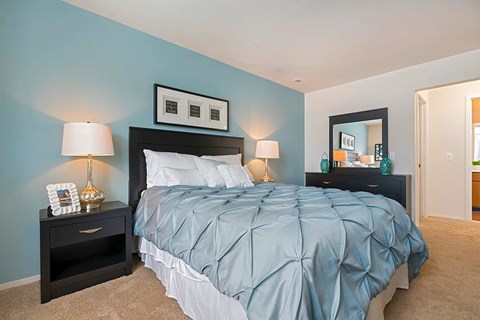 a bedroom with a blue wall and a bed