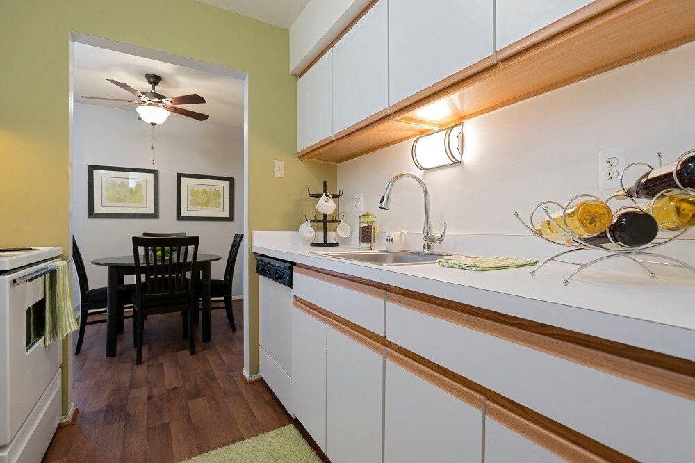 a kitchen with white cabinets and a sink and a dining table