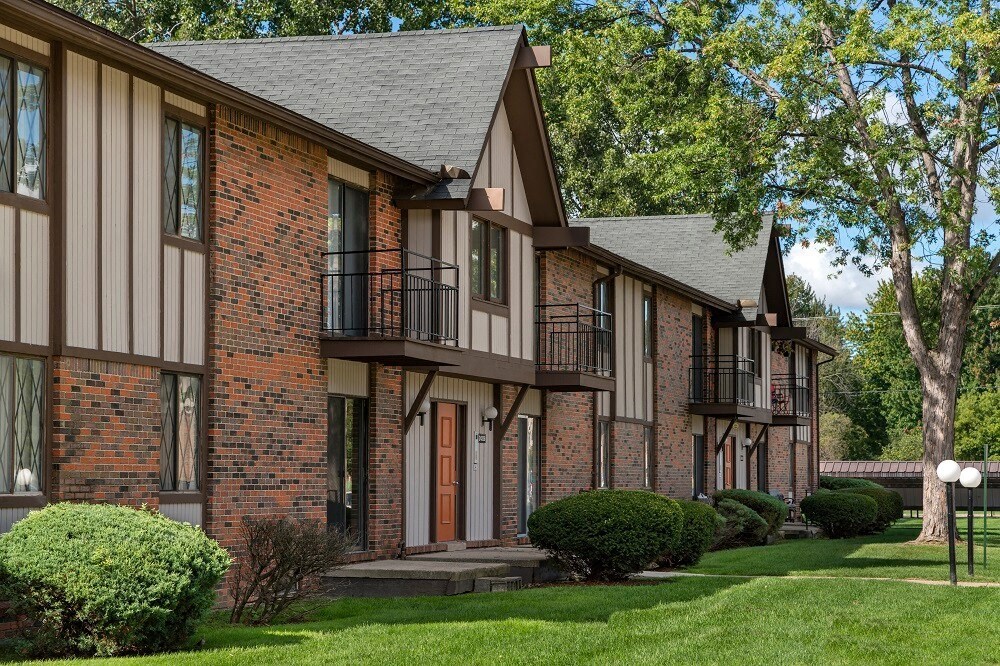 a view of a building with a lawn and trees