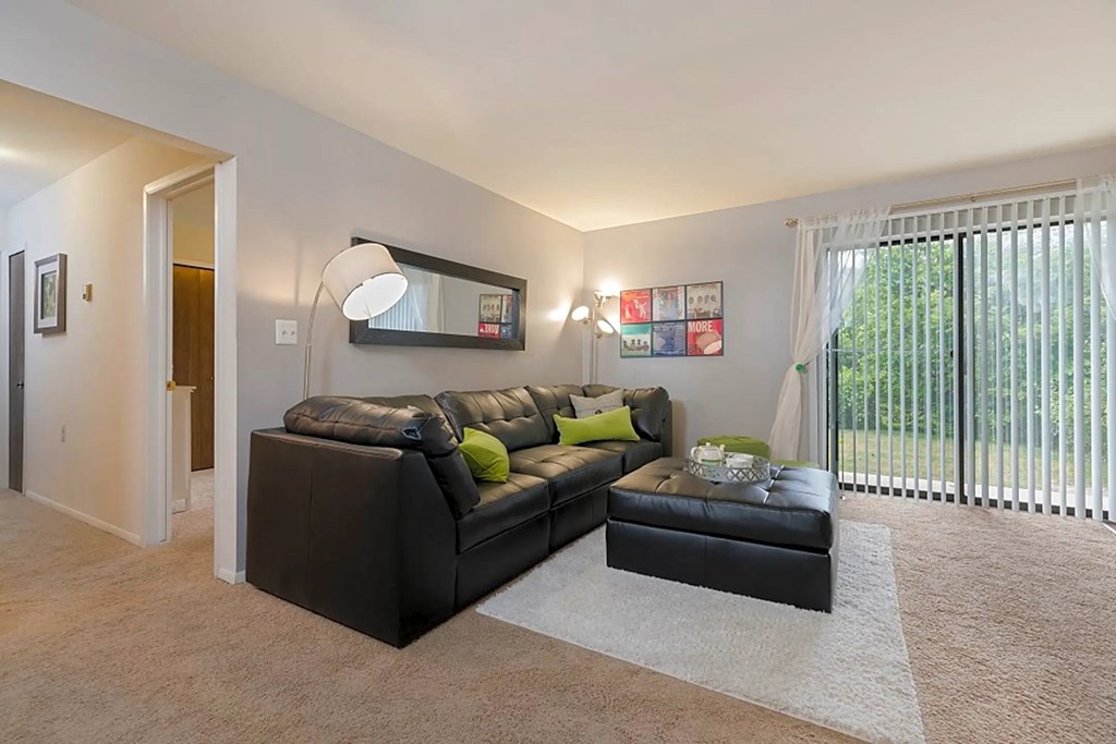 a living room with a leather couch and a large window