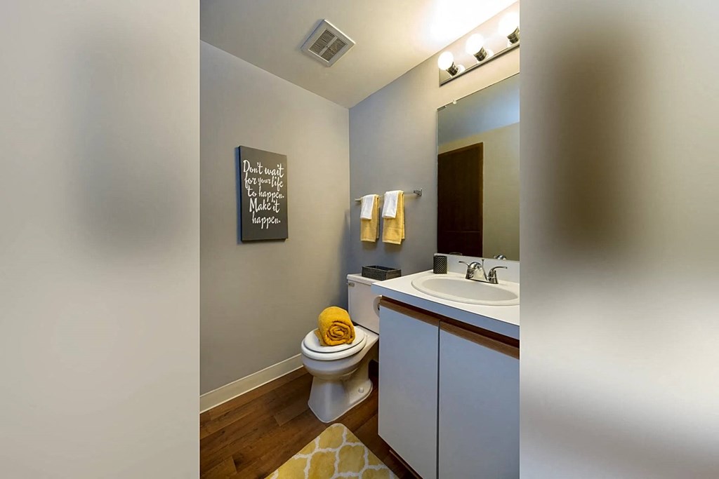 a bathroom with a toilet sink and a mirror