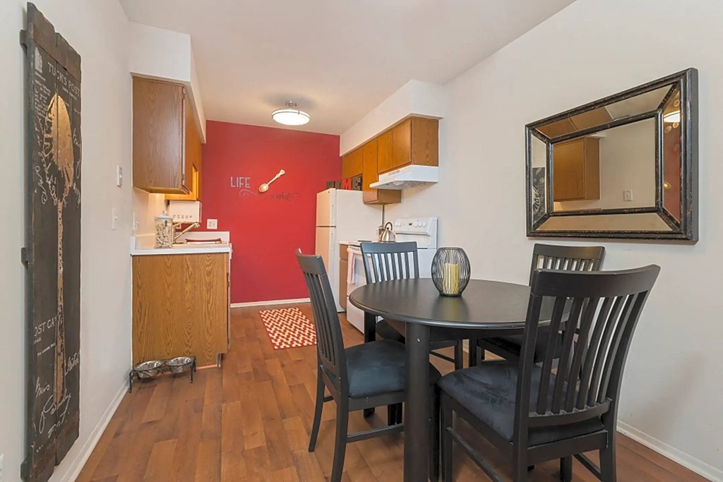 a dining room with a table and chairs next to a kitchen