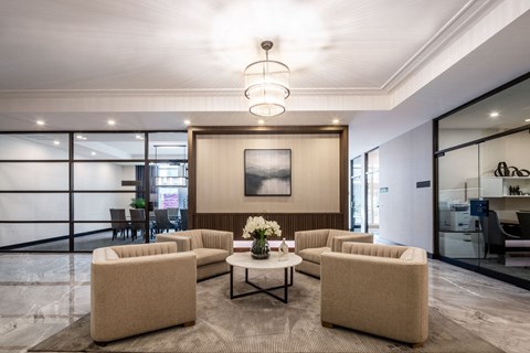A modern living room with a large painting on the wall and a coffee table in the center.