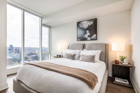 A bedroom with a large bed and a view of the city.