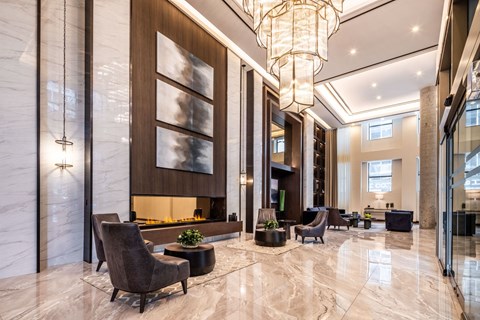 A spacious lobby with a marble floor and a large chandelier.