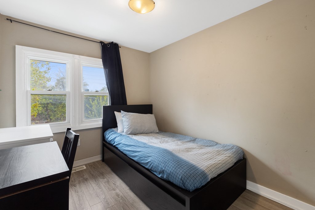an empty bedroom with a bed and a desk
