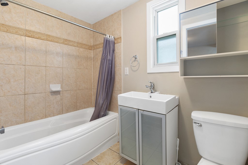 a bathroom with a tub and a sink and a toilet