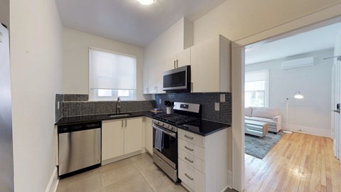 a kitchen with black counter tops and a stove and a microwave