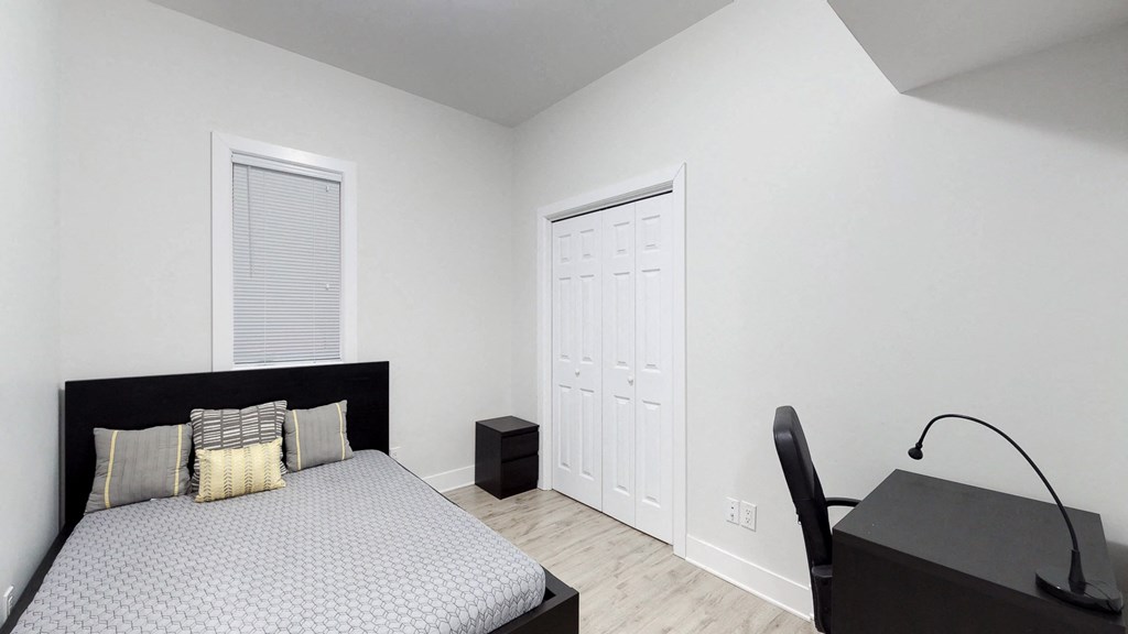 a bedroom with a bed and a desk and a closet