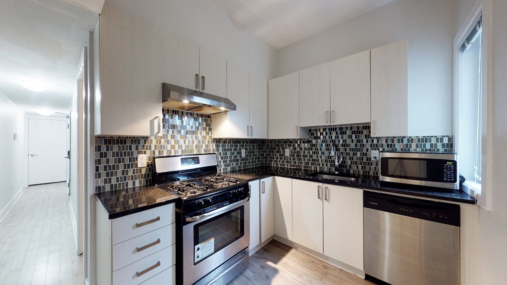 a kitchen with white cabinets and stainless steel appliances
