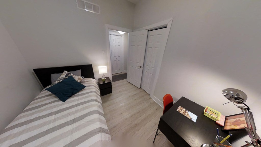 a bedroom with a bed and a desk and a closet