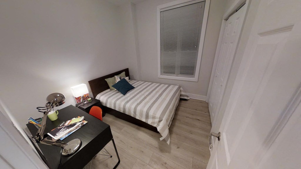 a small bedroom with a bed and a desk