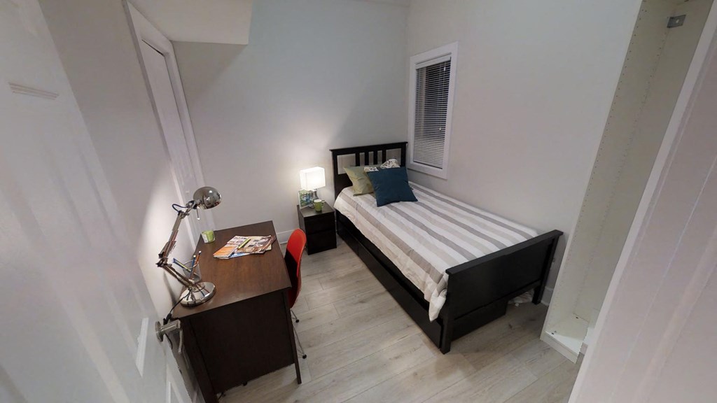 a small bedroom with a bed and a desk