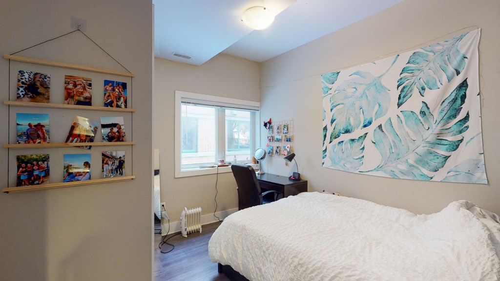 a bedroom with a bed and a painting on the wall