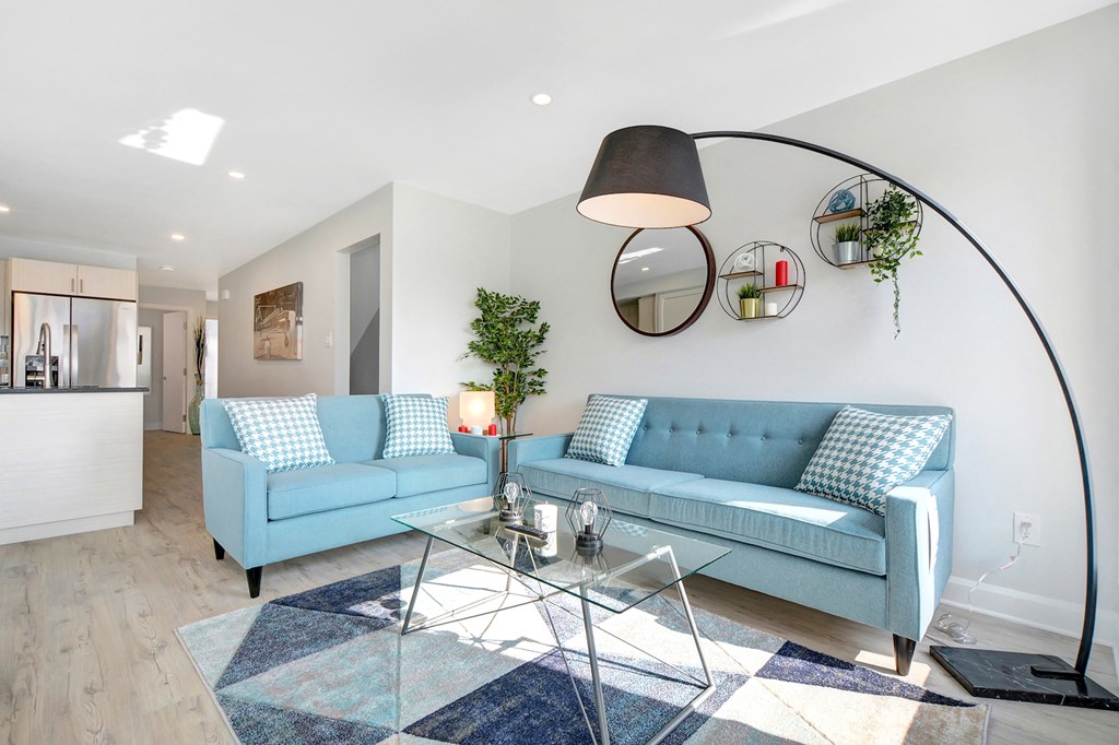 a living room with blue couches and a glass table