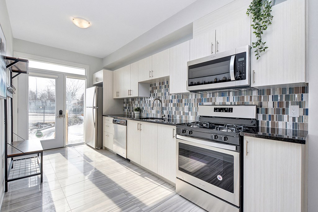 a modern kitchen with white cabinets and stainless steel appliances